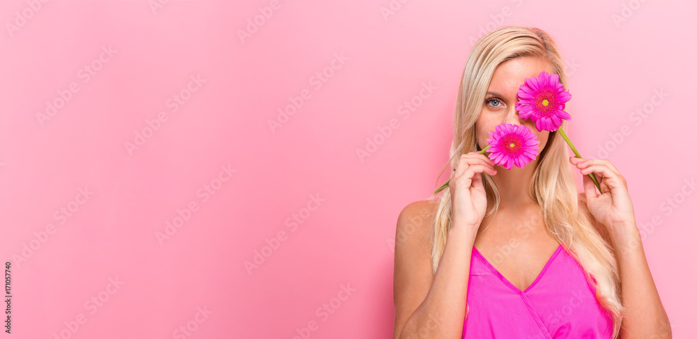 粉红色背景上有花的年轻女人
