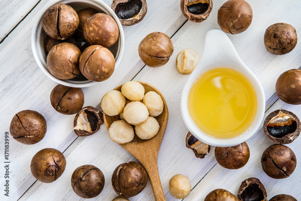  Macadamia Nut Oil and peeled macadamia nut   on white table ,﻿use for Healthy Skin and Hair and Nat
