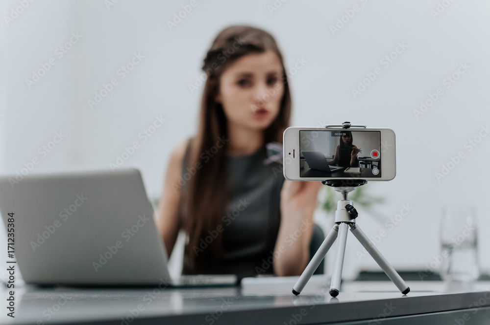 Woman vlogger recording business vlog at office desk
