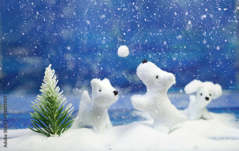 圣诞节和新年。白色可爱、快乐的小狗在蓝色圣诞树附近的雪球里玩耍