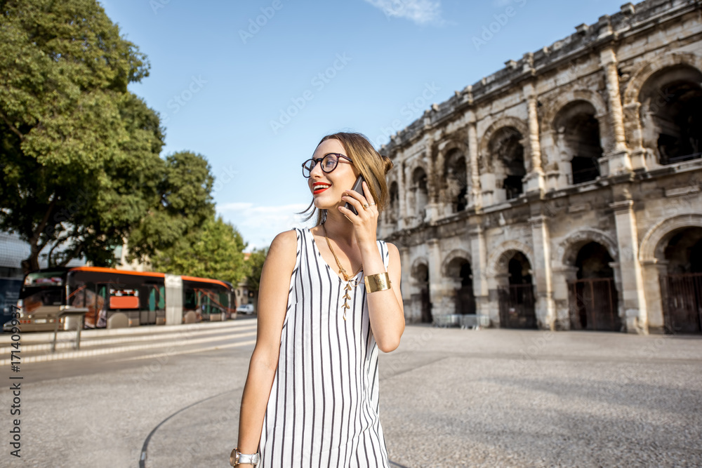 一位年轻女商人在法国尼姆市古老的罗马圆形剧场附近行走的生活方式肖像