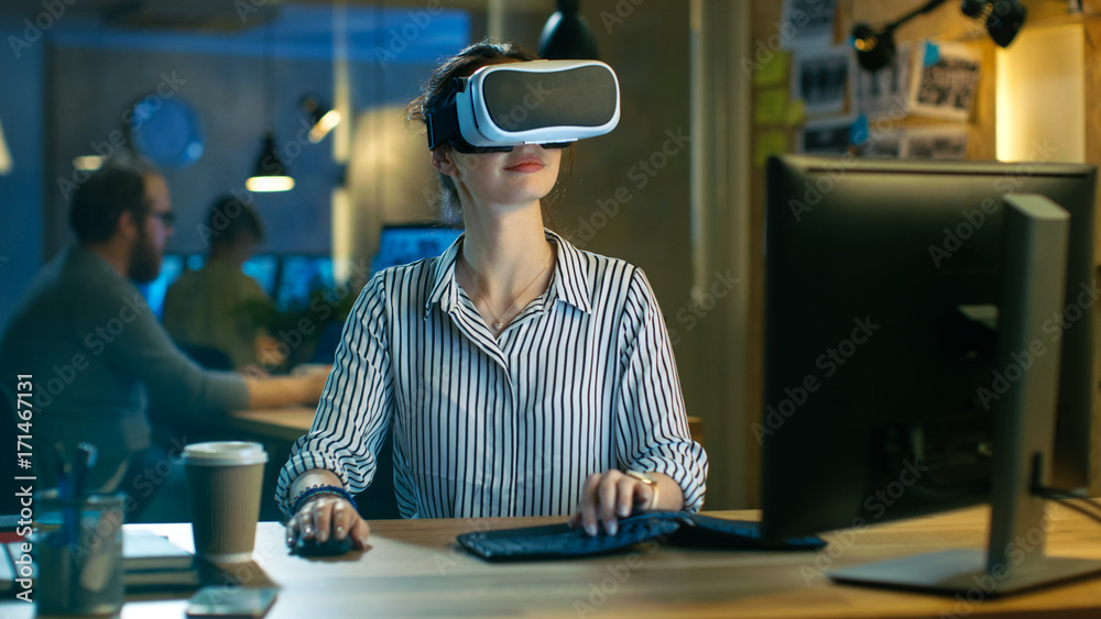 戴着VR耳机的美丽女性虚拟现实工程师/开发人员创建内容。她在i工作