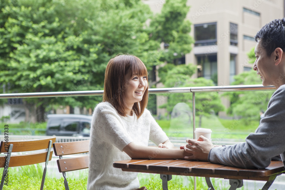 一对年轻夫妇在咖啡馆露台上愉快地交谈