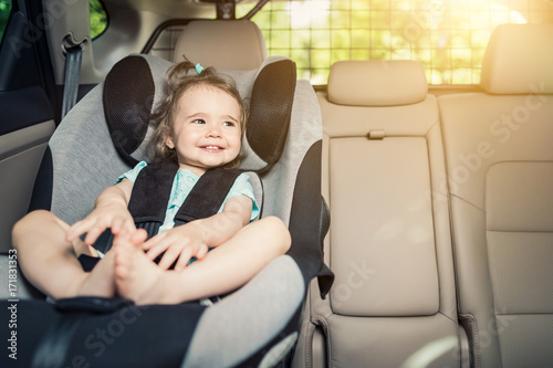 小女孩把安全带扣在汽车座椅上。
