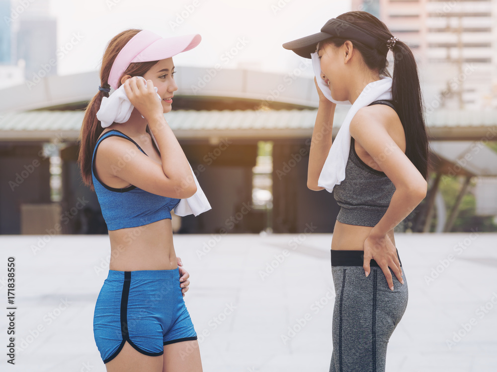两位穿着运动服的健康女性跑步者在交谈