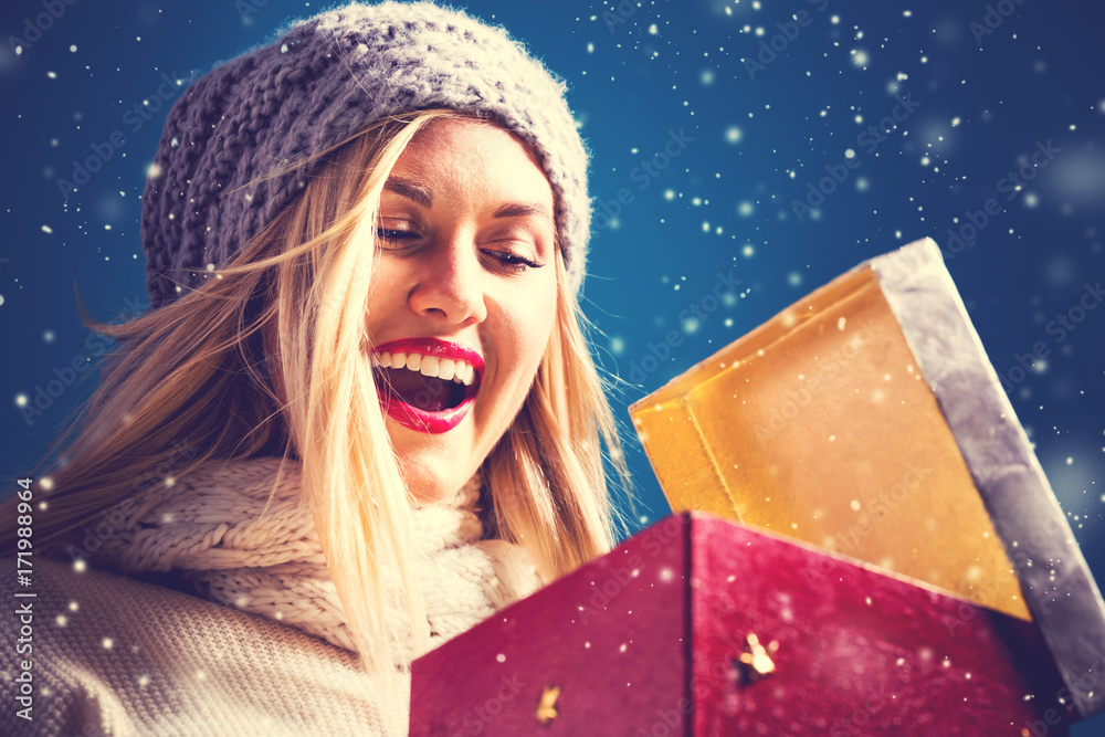 快乐的年轻女人打开圣诞礼物盒