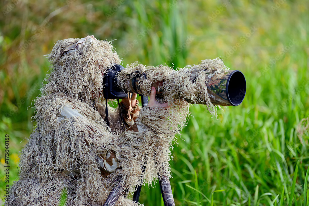 身着吉利套装的伪装野生动物摄影师