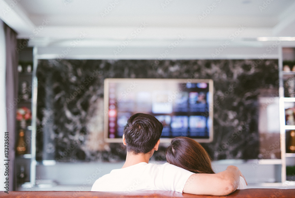 夫妻俩在客厅看电视的后视图