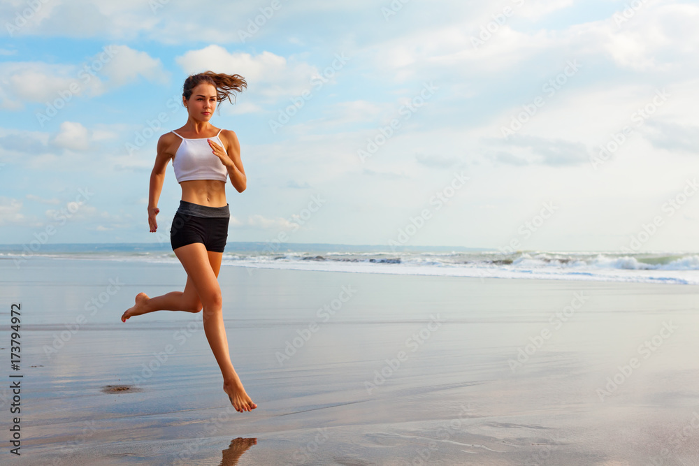 赤足运动女孩，苗条的身体，沿着水池边的海浪奔跑，以保持健康。Bea