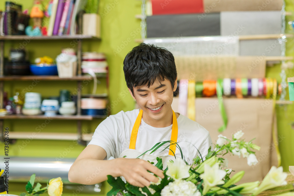 微笑的花店老板工作的肖像。小企业。