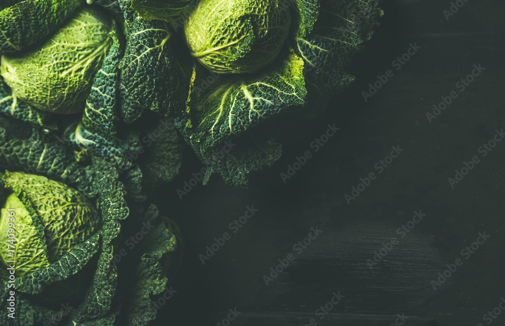 深色背景下的生的新鲜未煮熟的绿卷心菜，俯视图，选择性聚焦，复制空间