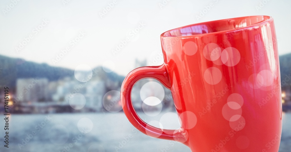 Red coffee cup with bokeh against blurry skyline