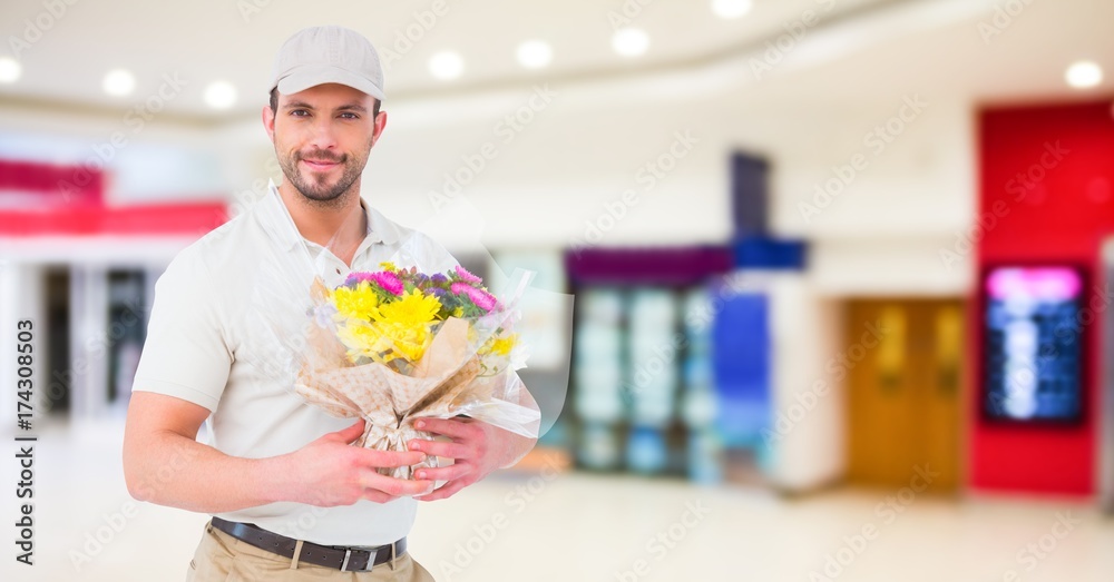 送餐员拿着鲜花对着模糊的购物中心