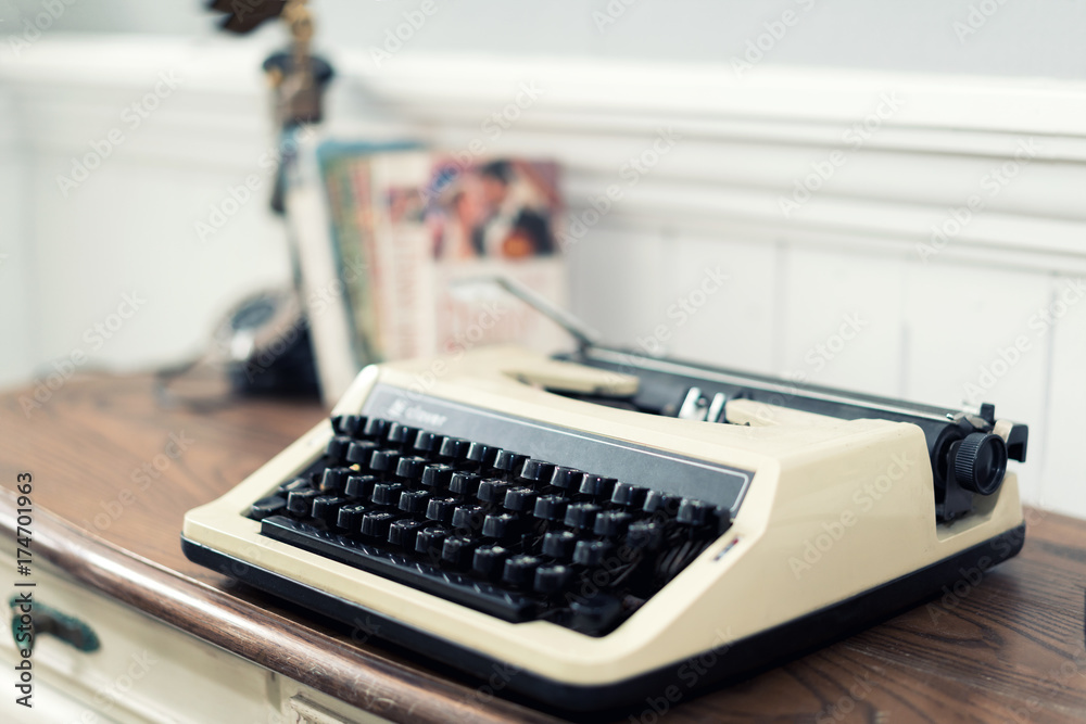Vintage typewriter and books on the table at home.