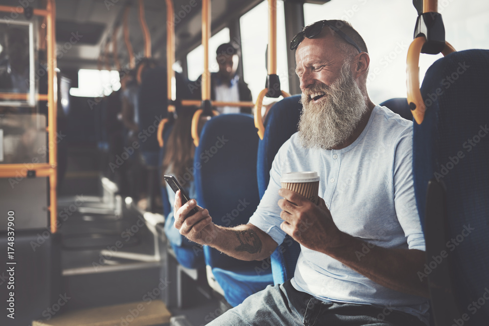 一个成熟的男人在公交车上用手机大笑