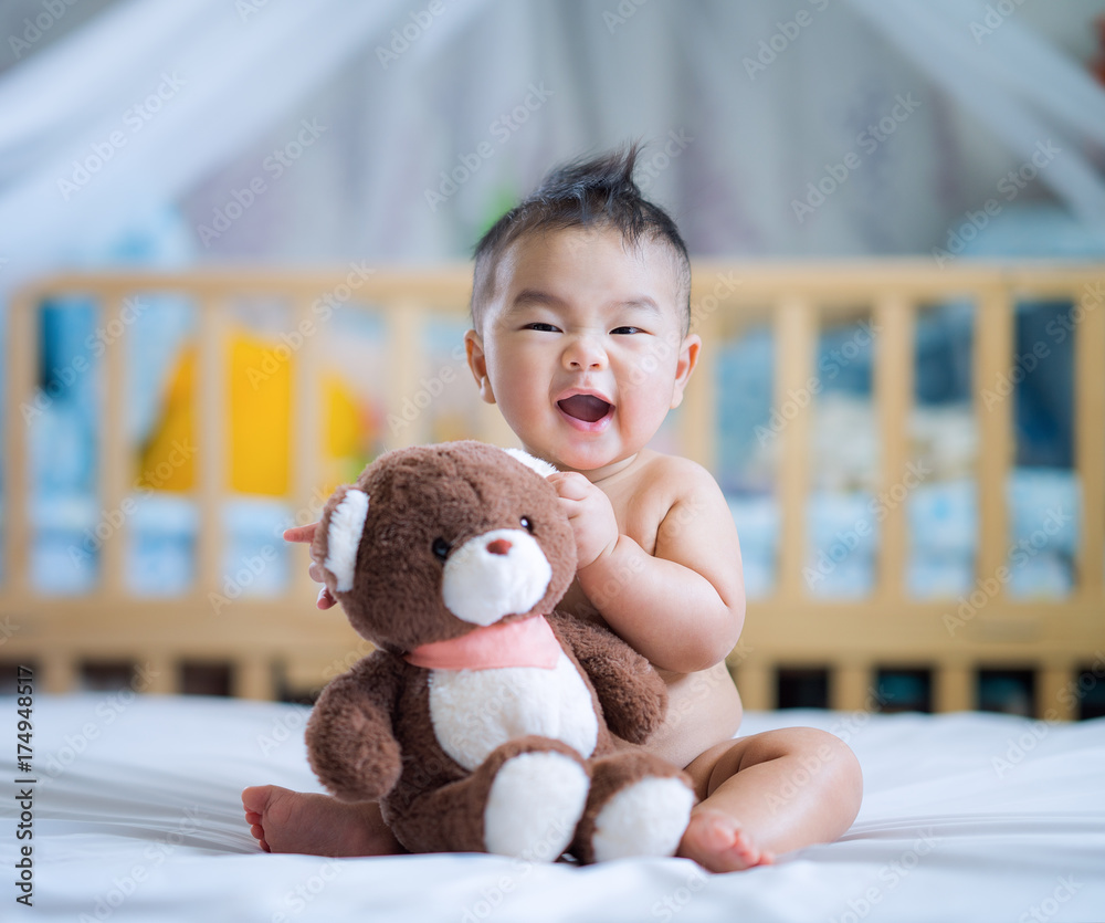 亚洲新生儿坐着拥抱泰迪熊