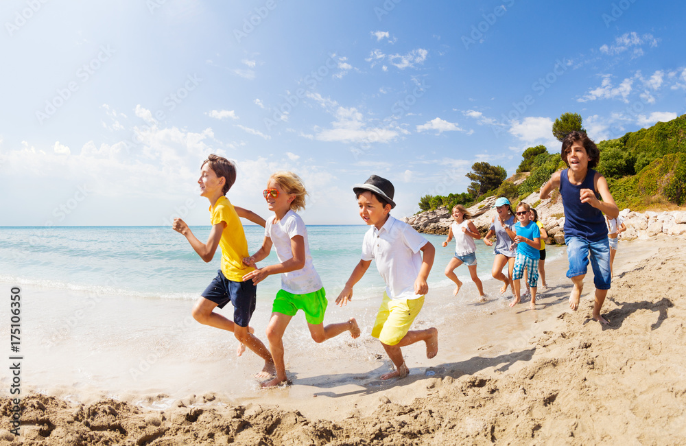 一大群孩子在海边的海滩上跑步