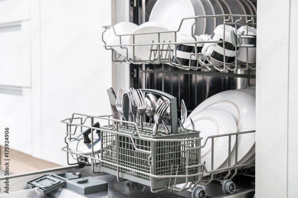 白色厨房里有干净盘子的开放式洗碗机