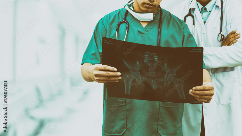 外科医生和医生正在看x光片。