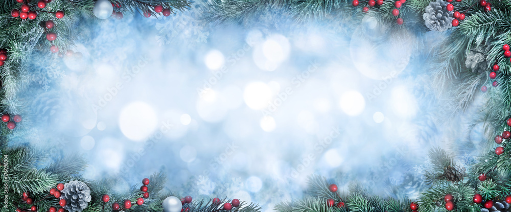 圣诞背景，以霜冻的冷杉树枝为框架，围绕着蓝色的bokeh复制空间