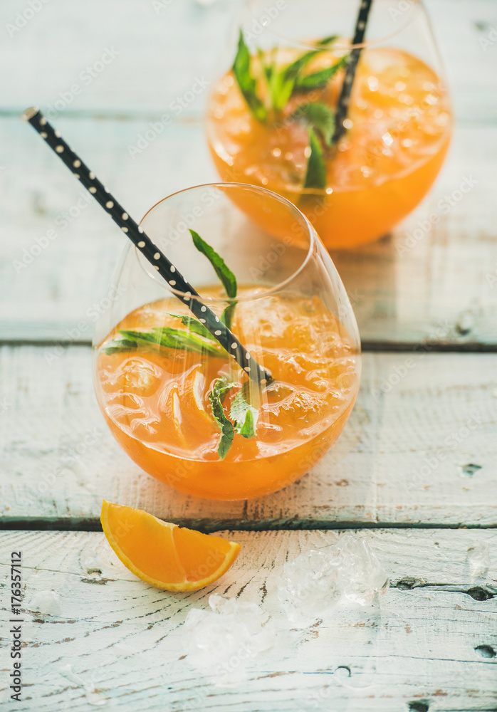 清爽的冷酒精夏季柑橘鸡尾酒，配无柄玻璃杯中的橙子、薄荷和冰块
