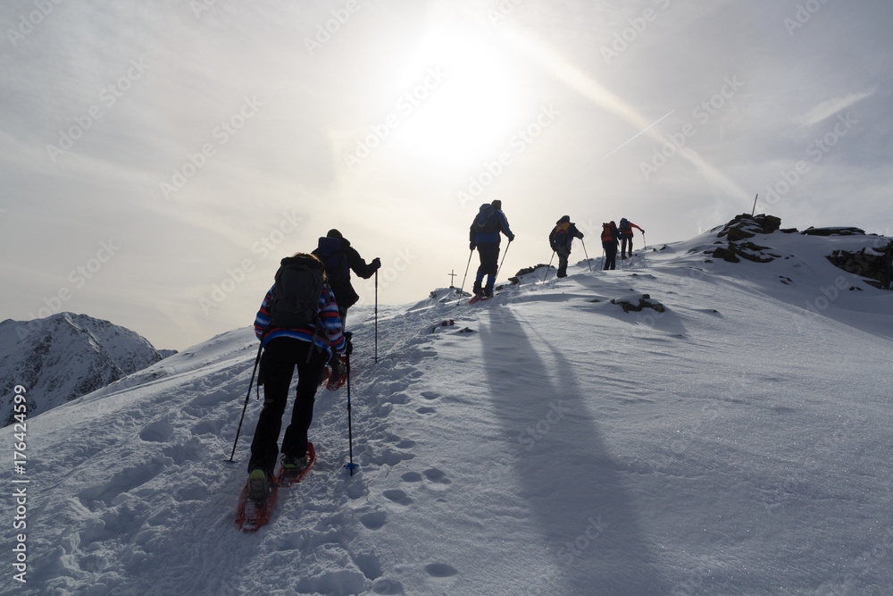 一群人穿着雪鞋徒步旅行，在澳大利亚斯塔拜阿尔卑斯山与山顶交叉处欣赏山雪全景