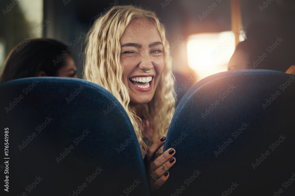 年轻女子坐在公交车上笑着眨眼