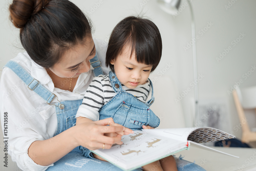 越南母亲和小女儿早上一起在客厅看书