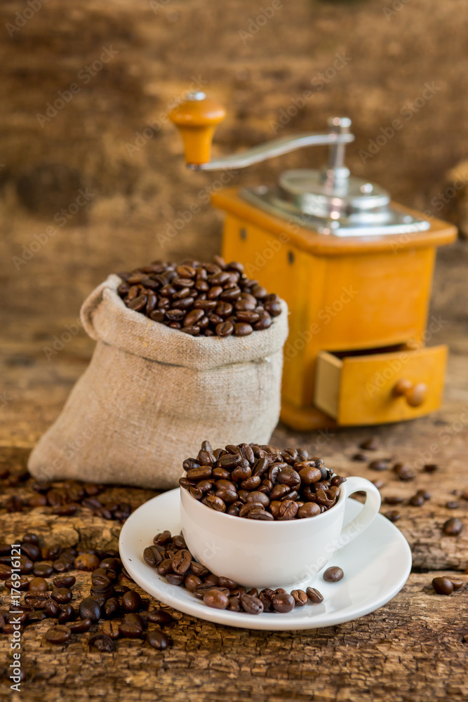 一杯咖啡豆。咖啡研磨机和背景是咖啡豆的袋子。