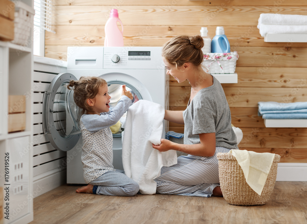 幸福的家庭主妇和孩子在洗衣机里。