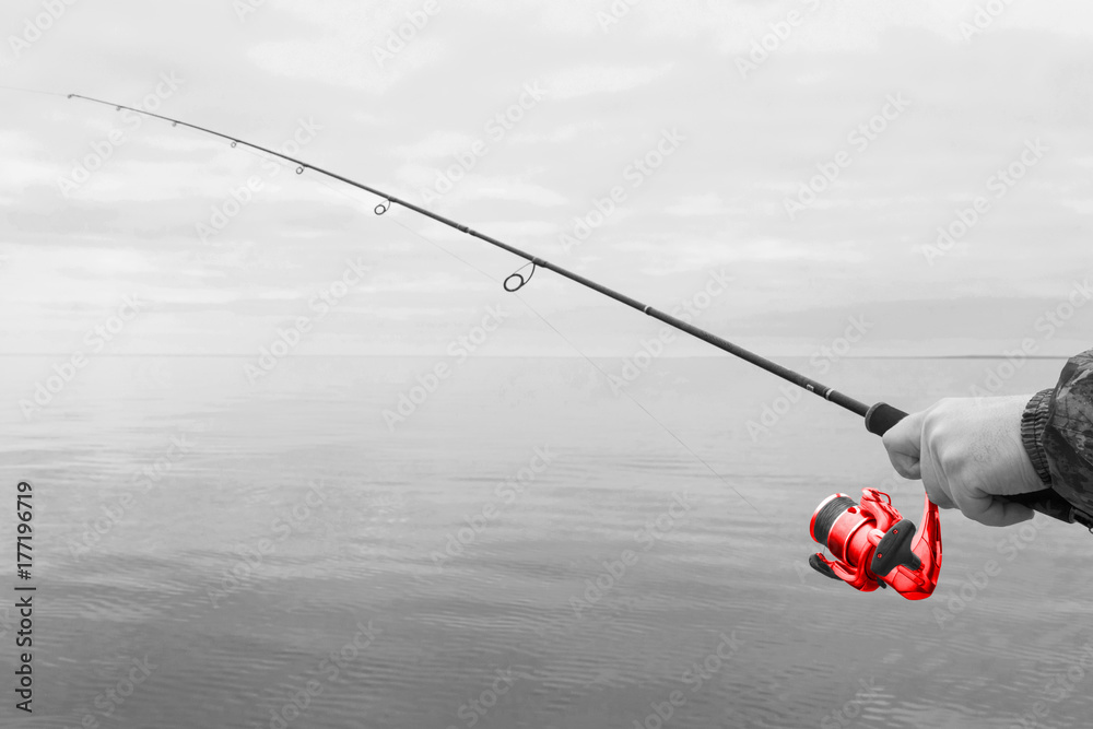 o湖摩托艇上一个渔夫的手，手里拿着一根红色的旋转杆，上面有一根绳子
