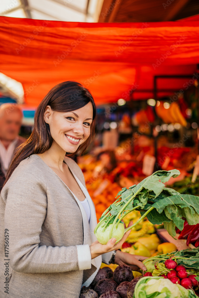 女人在市场上买食物。
