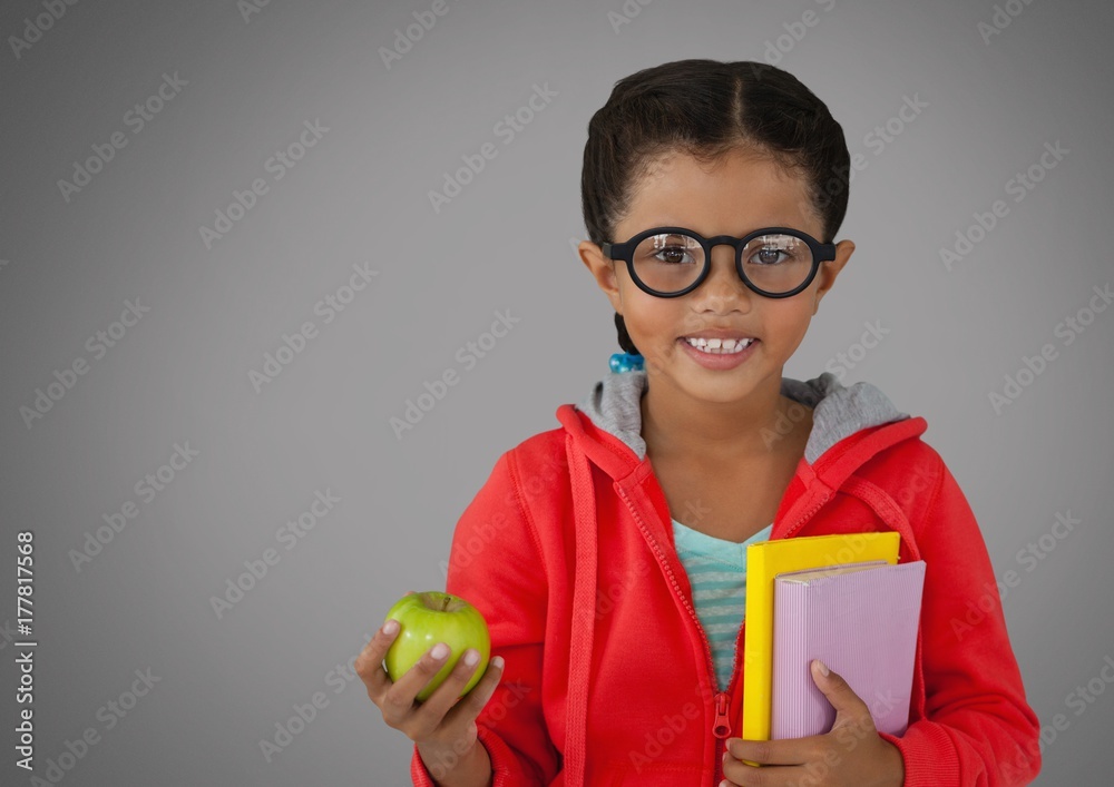 Girl against grey background with apple and books and glasses