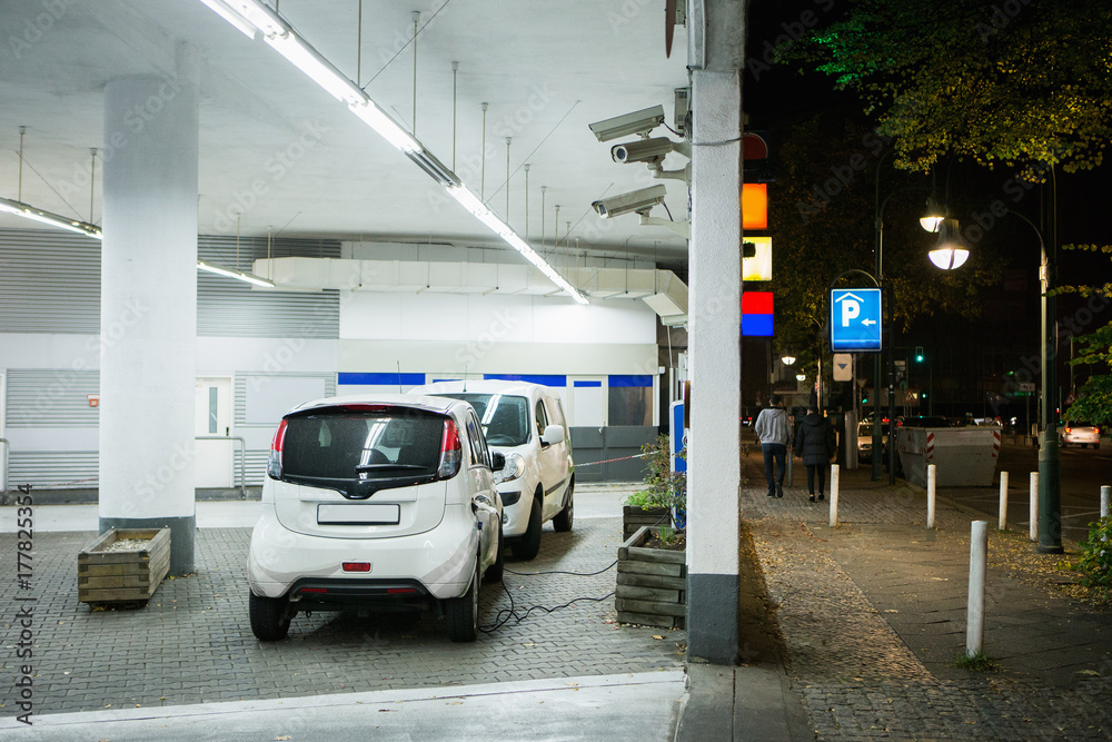 电动汽车夜间在购物中心室内停车场的充电站充电。