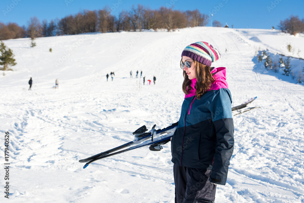 雪山上抱着滑雪板的女孩