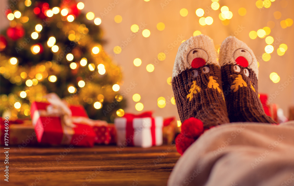 女人的腿配针织袜子，圣诞树配礼物的细节