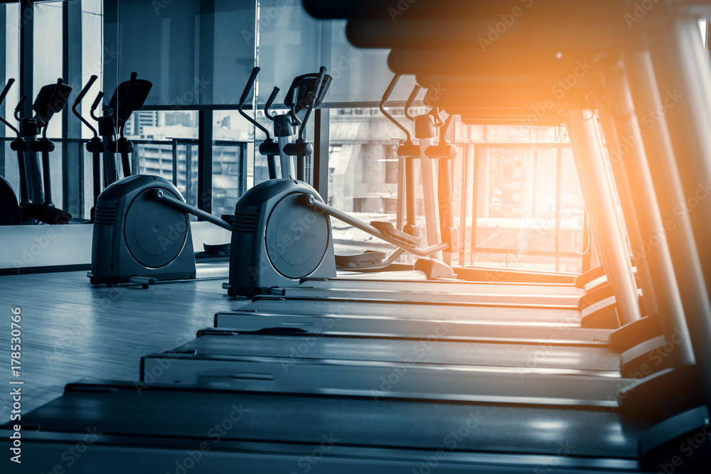 treadmill in fitness room background with color tone and light flare effect