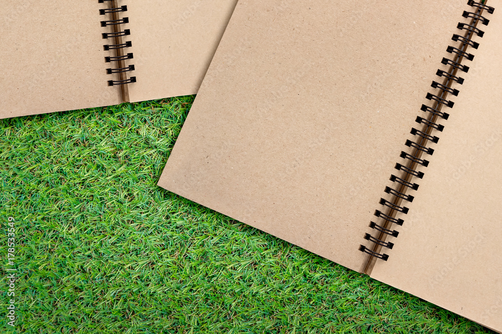 空白绿叶笔记本，在绿草纹理背景上提供免费复制空间