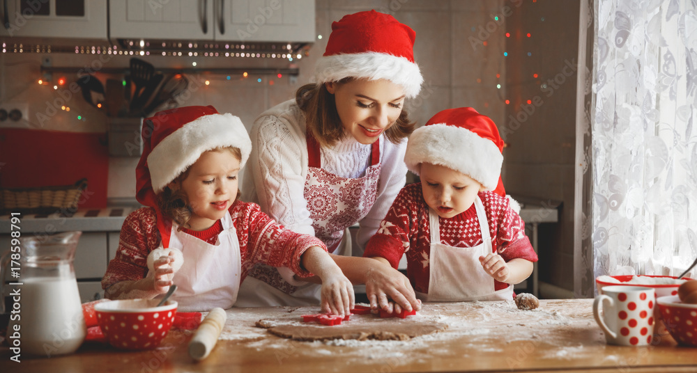 快乐家庭母亲和孩子为圣诞节烤饼干