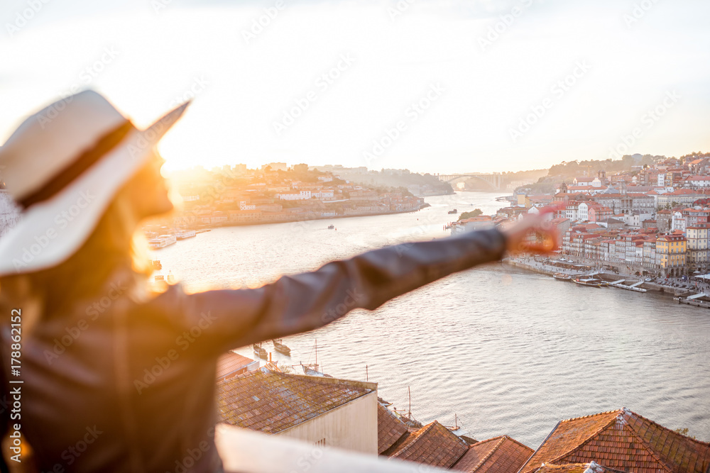 波尔托日落时，一名年轻女子用手指着美丽的城市景观背景