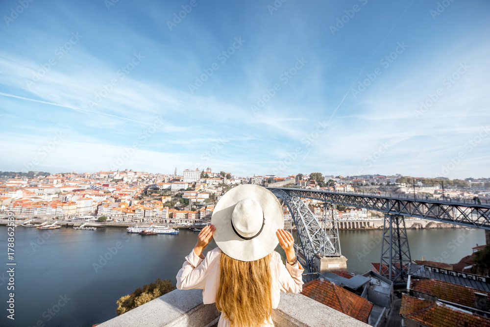 戴着太阳帽的年轻女性旅行者与杜罗站在美丽的空中城市景观背景上