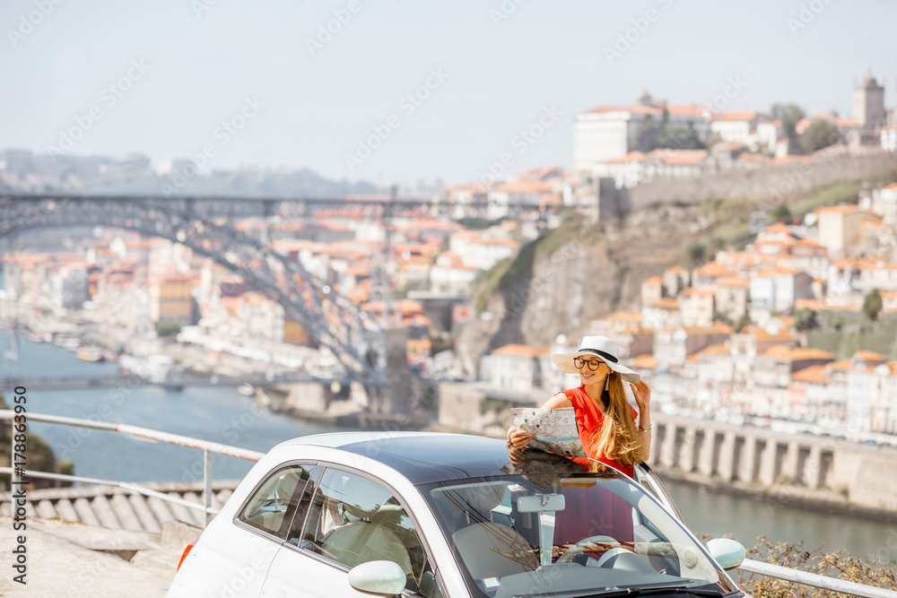 葡萄牙波尔图市一名身穿红色连衣裙的年轻女子驾车出行