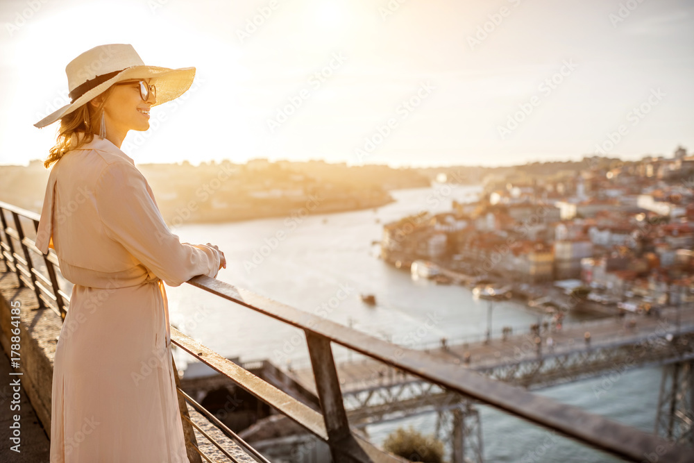 年轻的女游客在日落时分与著名的桥梁一起欣赏美丽的空中城市景观