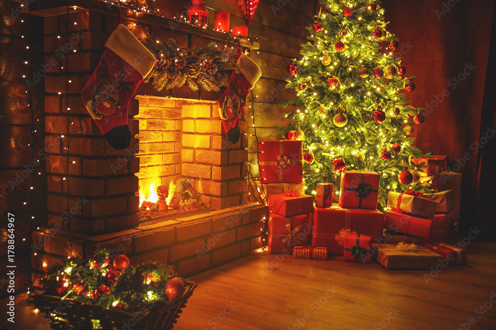室内圣诞。魔法发光的树，黑暗中的壁炉礼物