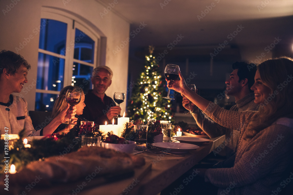 大家庭在圣诞晚餐上举杯庆祝