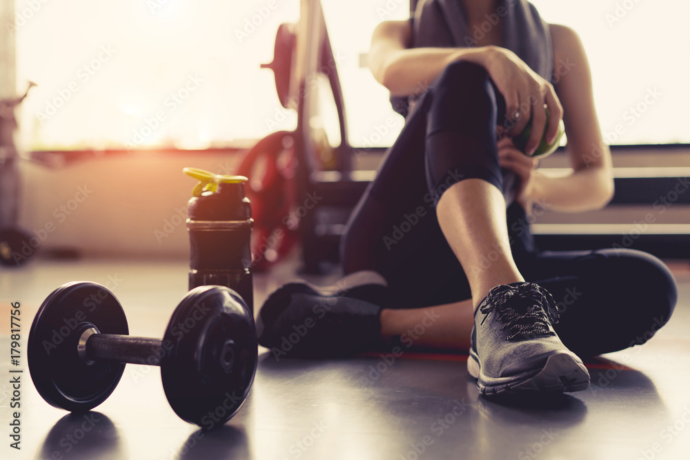 女性在健身房锻炼健身休息放松拿着苹果水果与d一起训练运动