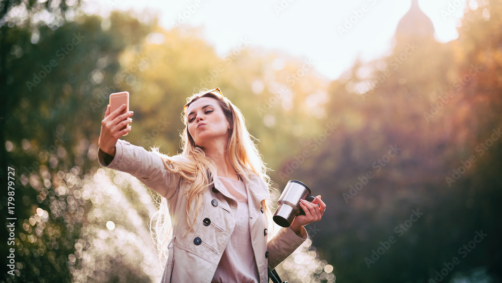 城市现代女性在户外智能手机上自拍