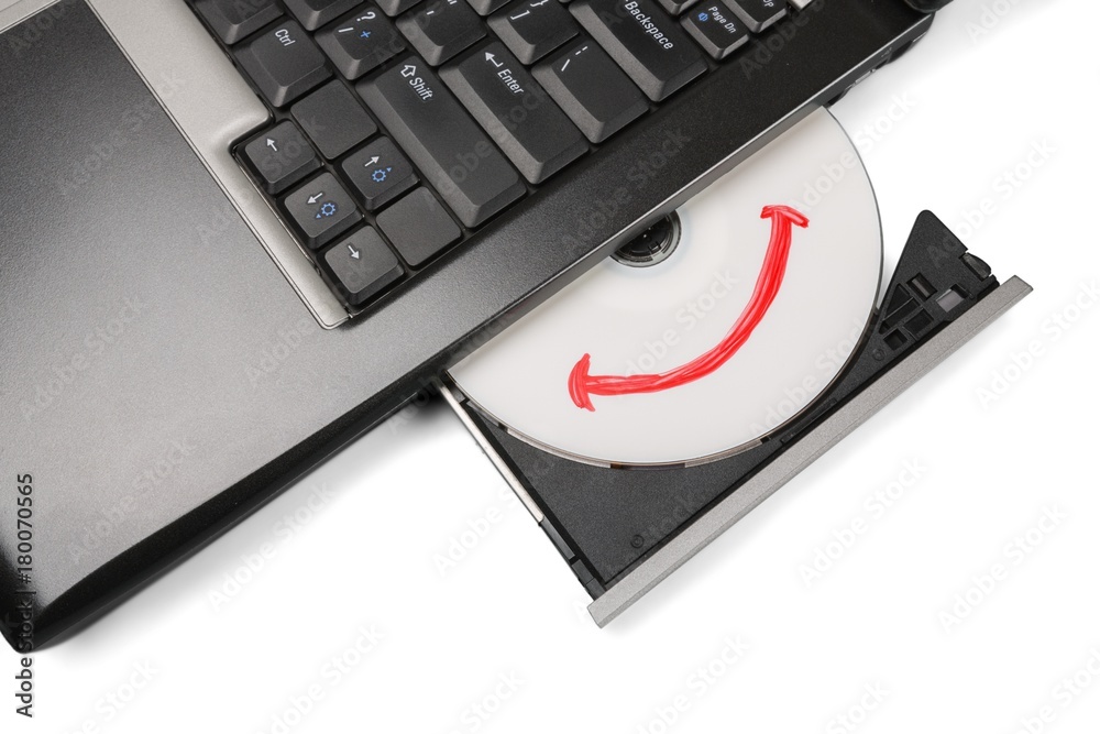 在笔记本电脑驱动器中插入带微笑的CD/DVD