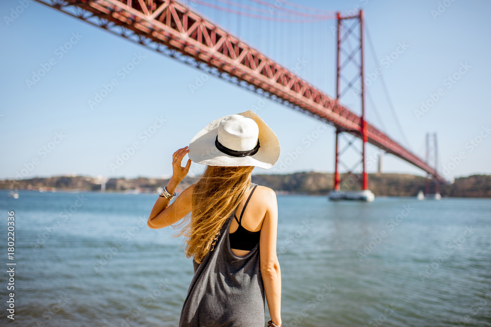 一位女士在著名的铁桥上欣赏美丽的风景，这座铁桥矗立在黎族河边