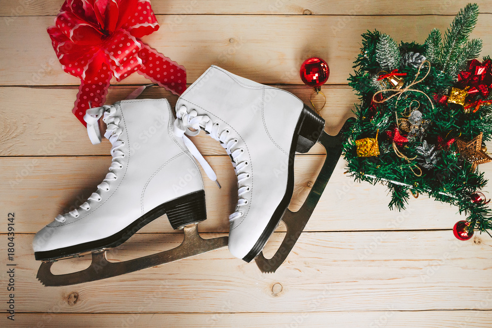 一双木制背景的溜冰鞋，带蝴蝶结作为礼物